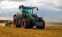 Landmand som høster halm med sin traktor